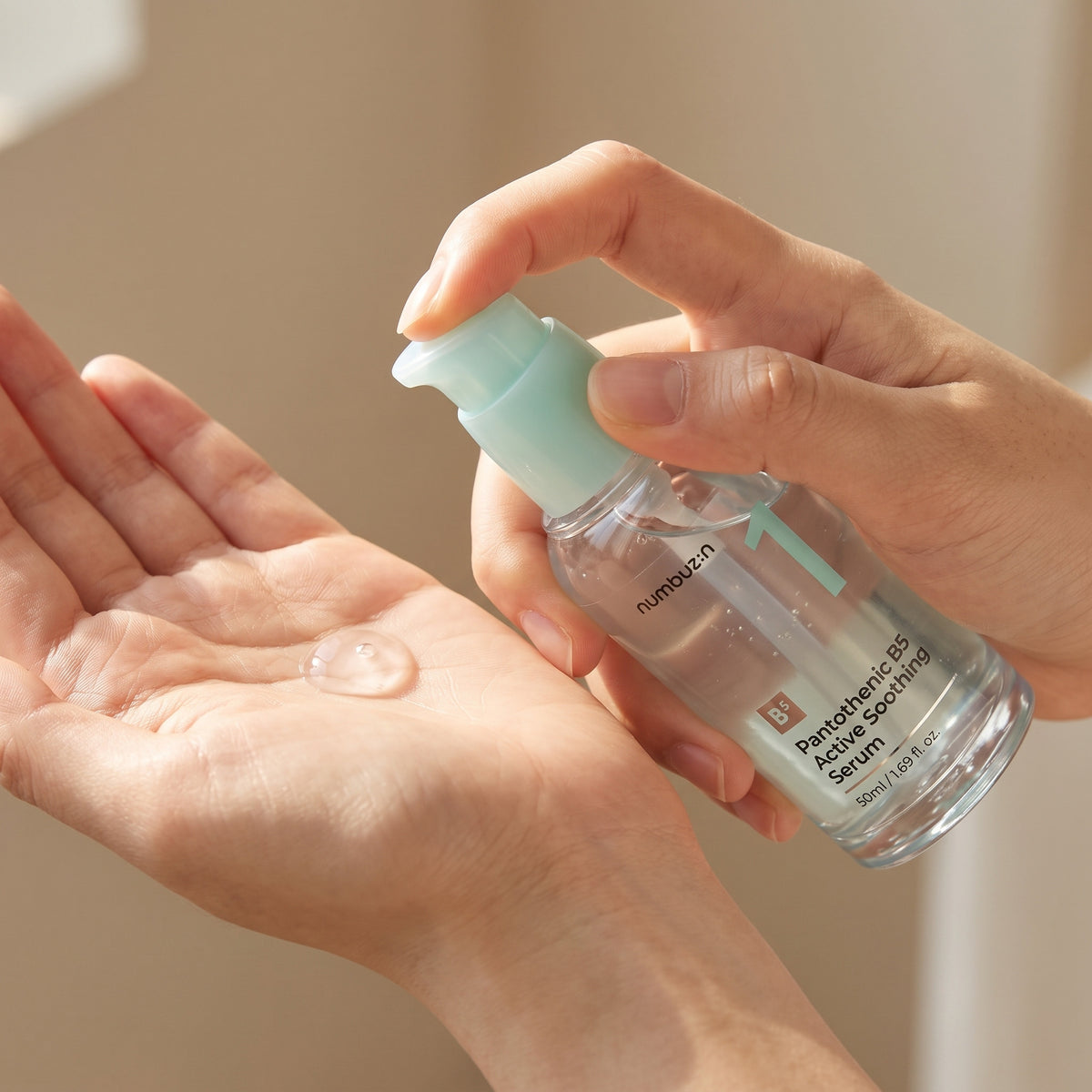 Clear NUMBUZIN No.1 Pantothenic B5 Active Soothing Serum pumped as a bead into an open palm